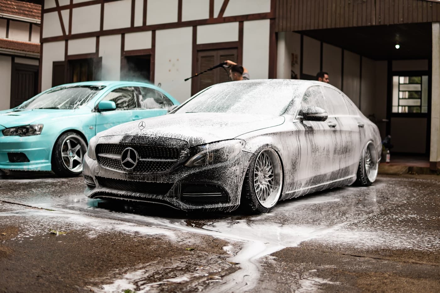 Mobile detailer washing multiple vehicles with foam and pressure washer